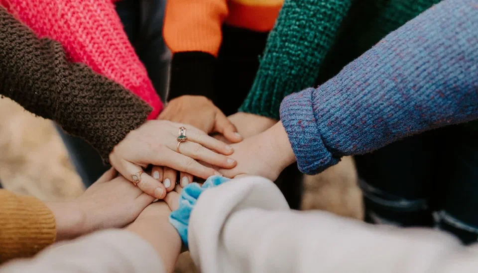 Women joining hands in a circle of support